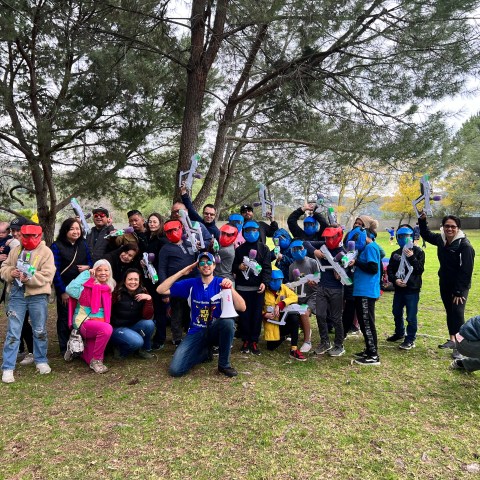 a group of people standing on top of a grass covered field