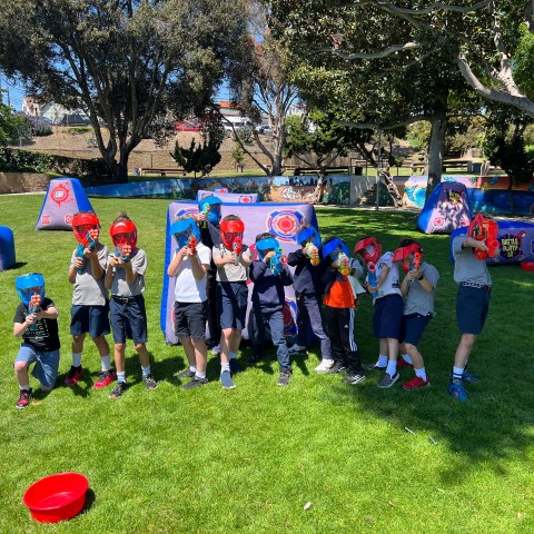 a group of people standing on top of a grass covered field