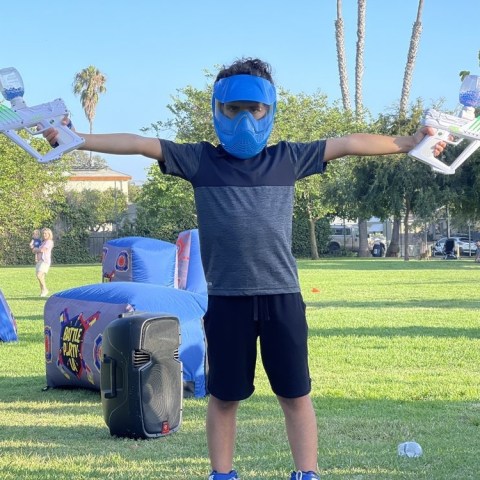 a young man standing on top of a grass covered field